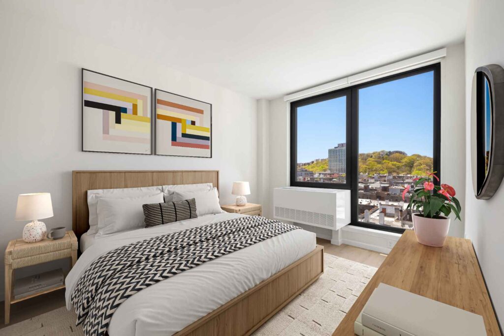 Stylish bedroom with modern decor and huge windows w/ park views at Tryon North apartments in Inwood near Fort Tryon Park.