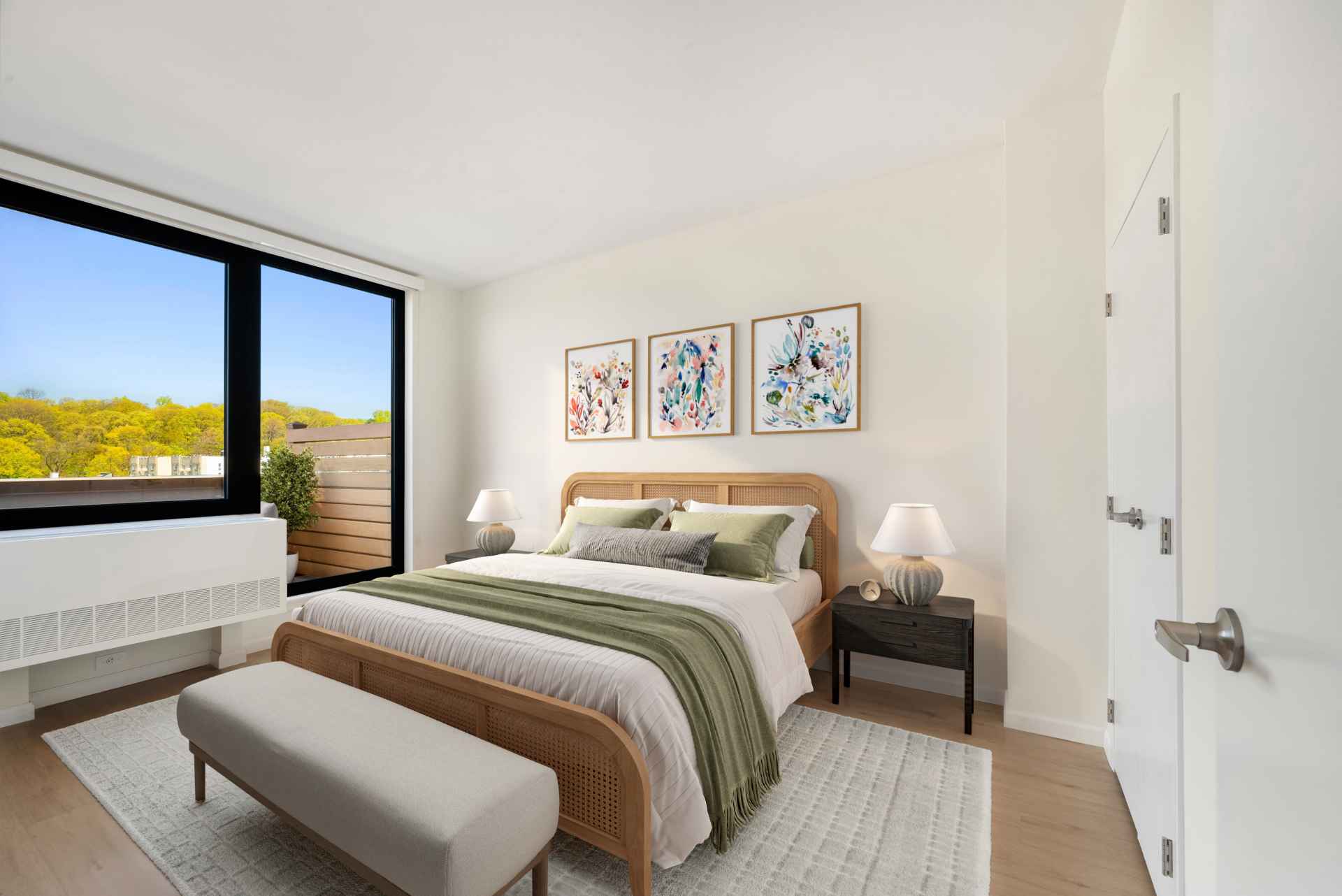 Luxurious bedroom with modern decor and huge windows w/ park views at Tryon North, Inwood apartments near Fort Tryon Park.